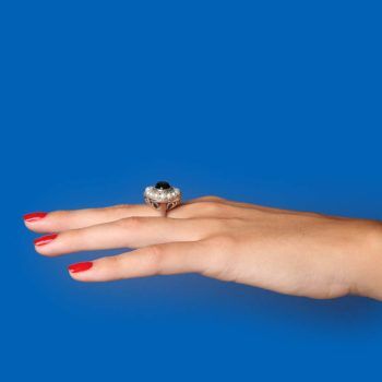 hand on blue background with second hand Tiffany ring - tiffany & co history