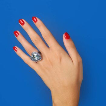 hand on blue background with second-hand Mauboussin ring